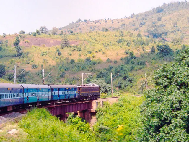 This is the picture of a train which is on the train track and around there are some mountains on...