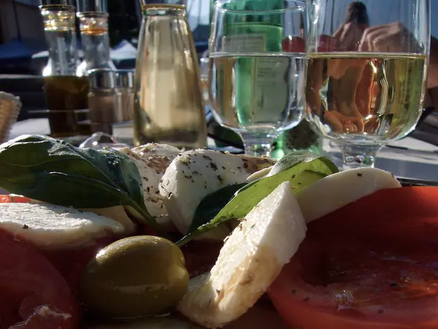 In this picture i could see some food placed on the plate and the wine glasses filled with wine....